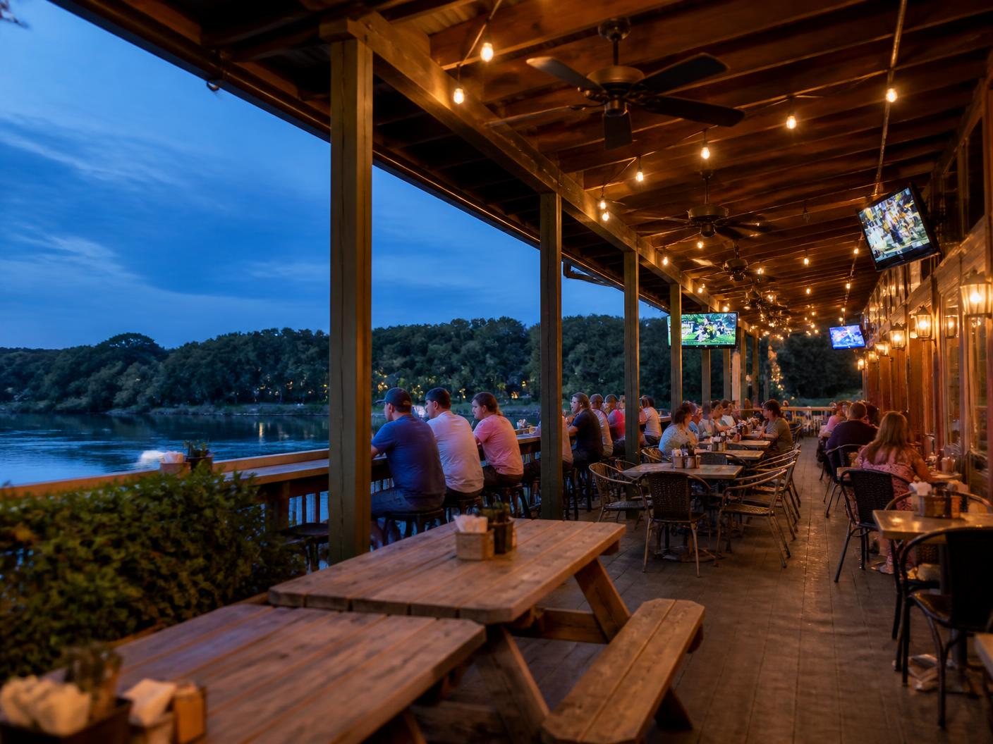 String lights and ceiling fans over the deck at blue hour